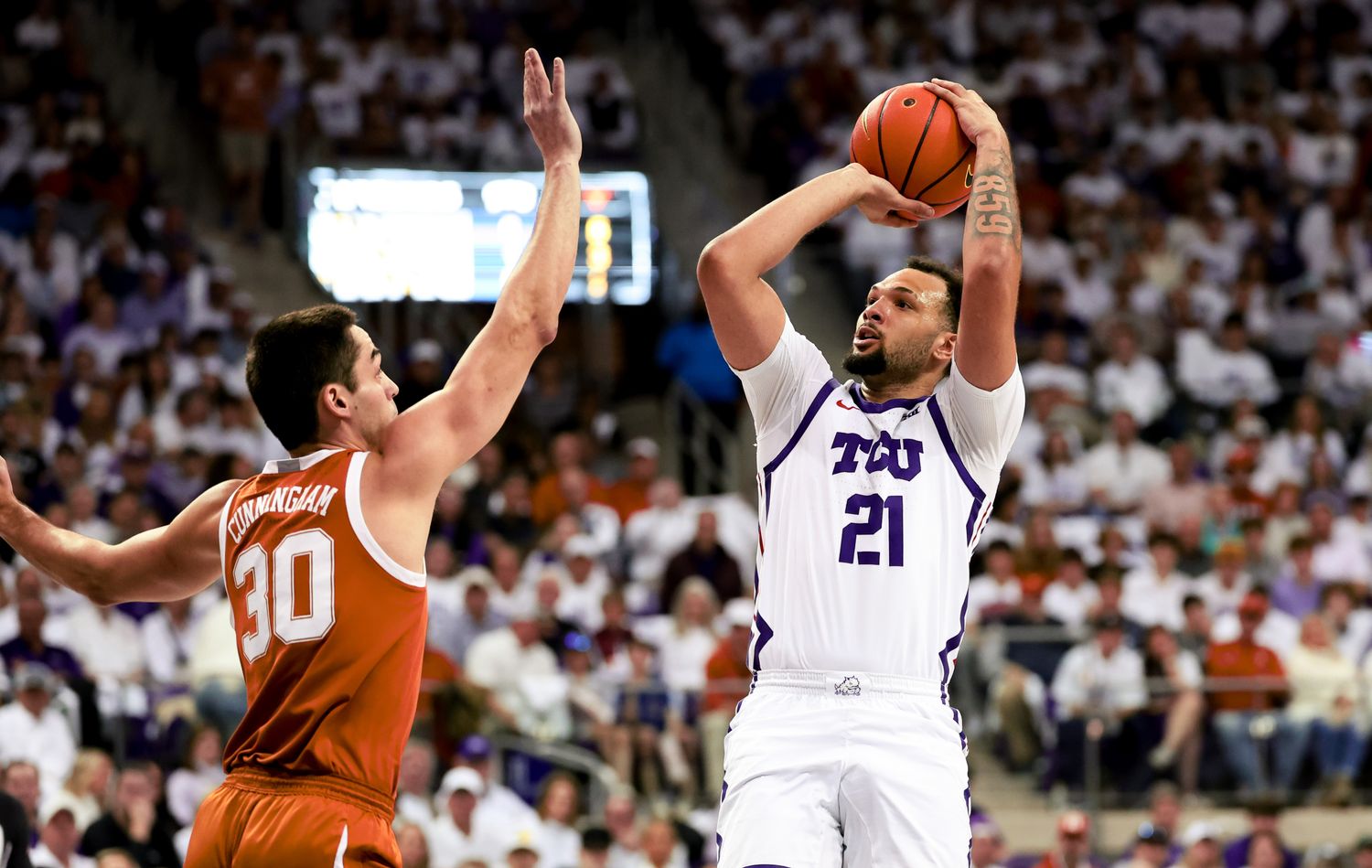 Feb 3, 2024; Fort Worth, Texas, USA; TCU Horned Frogs forward JaKobe Coles (21) shoots over Texas Longhorns forward Brock Cunningham (30) during the first half at Ed and Rae Schollmaier Arena. Mandatory Credit: Kevin Jairaj-USA TODAY Sports